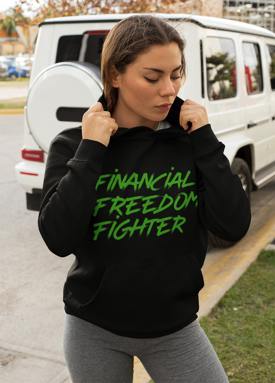 a woman showing the frontside of a black colored hoodie from the brand Stanley Stella with the inscription "Financial Freedom Fighter" in large green letters