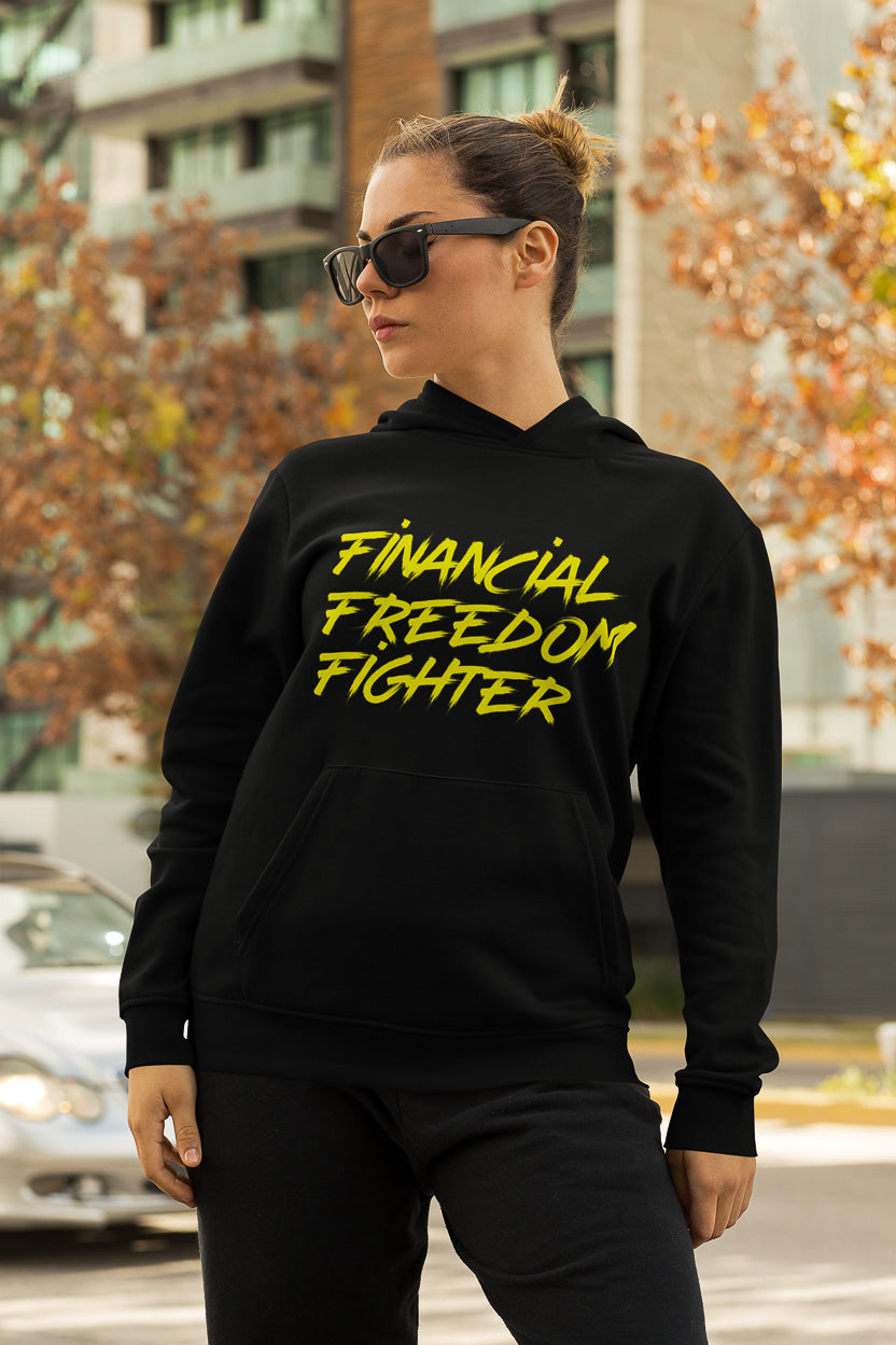 a woman showing the frontside of a black colored hoodie from the brand Stanley Stella with the inscription "Financial Freedom Fighter" in large yellow letters