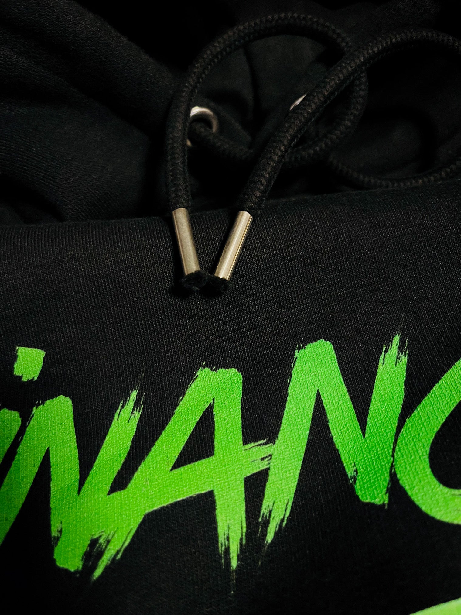 black hoodie zoomed details of green print